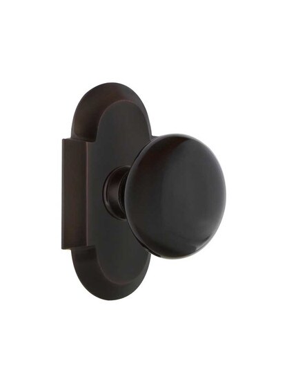 Arched Rosette Door Set with Black Porcelain Knobs in Timeless Bronze.